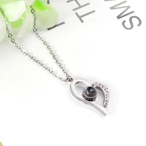 Detail of silver heart projection necklace with micro-pave crystals and a black gem