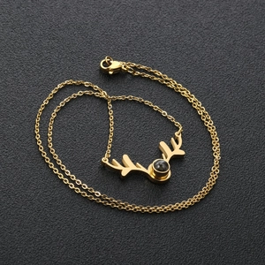 Detailed view of gold reindeer antler pendant necklace with black projection stone