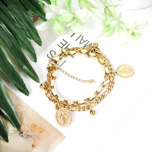Bracciale a doppia catena dorata con ciondoli a moneta e icone religiose della Vergine Maria