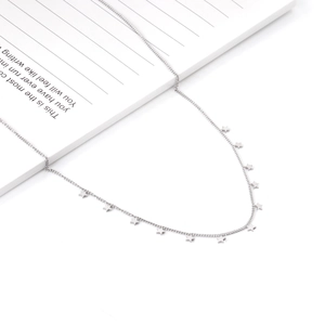 Macro detail of silver tone stainless steel O-chain necklace with multiple star pendants