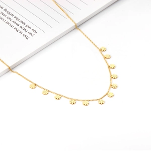 Close-up of golden stainless steel daisy flower charms on a delicate link chain necklace