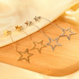 Boucles d'oreilles pendantes étoile évidée en or et argent sur présentoir en bois