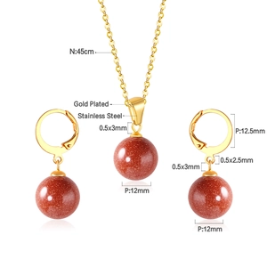 Détail de la parure en acier doré avec pendentifs ronds en pierre verte de 12mm