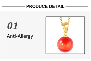 Détail macro du pendentif en pierre œil de chat rouge sur collier doré antiallergique