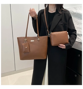 Détail du set de sacs en cuir marron grainé avec plaques décoratives en métal doré clair