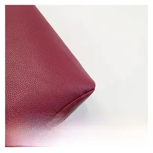 Macro de la texture en similicuir bordeaux à motif litchi avec détails de surpiqûres