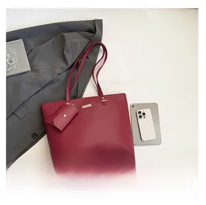 Sac fourre-tout bordeaux et pochette avec ordinateur et smartphone pour échelle de taille