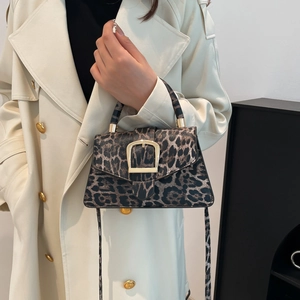Chic leopard print crossbody bag with gold buckle on a long beige trench coat