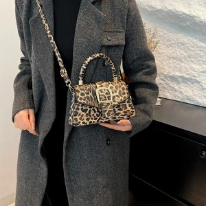 Retro leopard print crossbody bag with gold buckle shown on a model in a grey wool coat