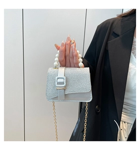 Détail du mini sac à paillettes argentées avec poignée en perles et chaîne dorée