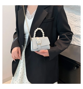 Détail du sac argenté pailleté avec poignée en perles et bandoulière en chaîne