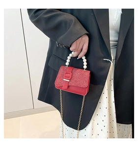 Détail du mini sac rouge avec poignée en perles et finition scintillante pailletée