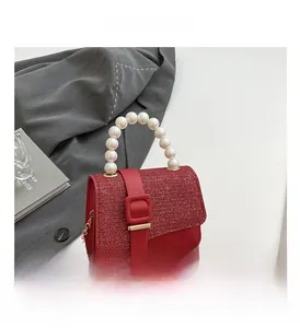 Gros plan du mini sac carré rouge à paillettes avec anse perle et chaîne dorée