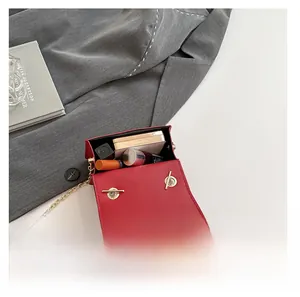 Détail du mini sac bandoulière rouge montrant la capacité pour rouge à lèvres et poudre