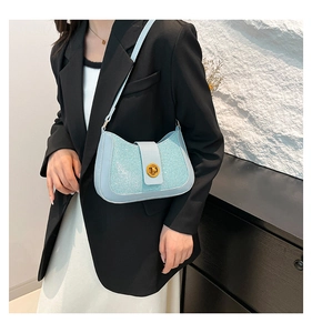 Light blue sequined shoulder bag with gold circular twist lock on elegant fabric