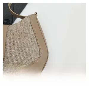 Detail showing contrast between woven fabric and smooth leather texture on women's bag