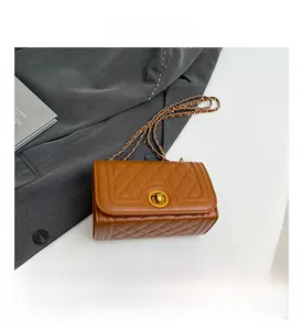 Close-up of brown quilted faux leather texture with gold chain strap and turn-lock