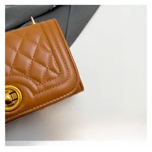 Close-up of brown quilted handbag featuring a golden metallic rotating twist lock