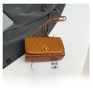Detailed view of brown quilted bag size comparison with a smartphone and chain strap