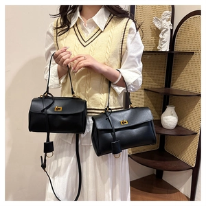 Detail showing two sizes of black leather tote bags with elegant gold metal twist locks