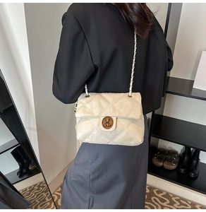 Dettaglio borsa trapuntata beige con texture pelle stropicciata e fibbia dorata