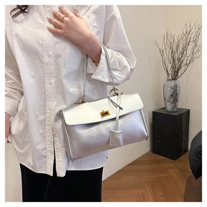 Silver leather tote bag featuring a golden twist lock closure and decorative hangtag detail