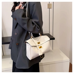 Detail showing high-quality white leather tote with double metal twist locks and side ring