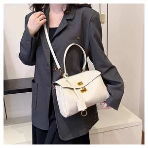 Detail of cream white tote bag featuring leather texture and golden twist lock closure