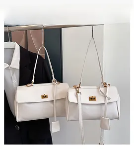 Detail view of large and small white leather tote bags with elegant golden twist lock buckles