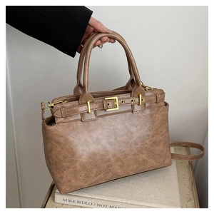 Detail of vintage brown tote bag with marble texture and golden hardware accents