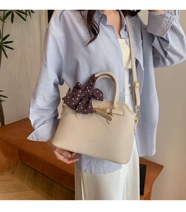 Detail of beige lychee grain tote bag with silk scarf on handle and metal lock