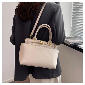 Model showcasing a beige retro tote bag with golden buckle and adjustable strap