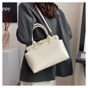 Modern cream leather tote bag featuring golden hardware and versatile shoulder strap
