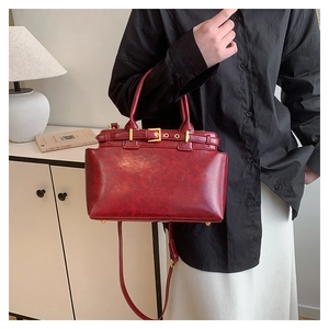Detailed view of vintage red tote bag with distressed faux leather finish and top handles