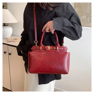 Close-up of deep red marble texture tote bag with golden hardware and buckle detail