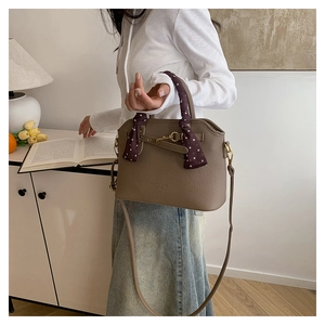 Close-up of vintage brown lychee leather tote bag featuring a decorative purple silk scarf