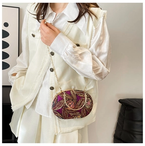 Détail d'un sac de soirée vintage avec broderies dorées, paillettes et poignée métallique