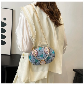 Détail de broderie de paillettes florales sur pochette de soirée ovale avec chaîne