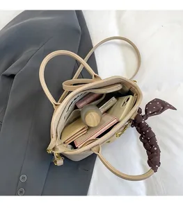 Close-up of beige lychee leather tote bag interior with polka dot scarf and spacious storage