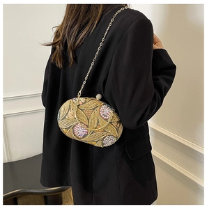 Détail d'une pochette de soirée vintage avec broderies dorées et sequins floraux colorés