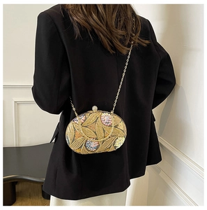 Détail de la broderie florale avec paillettes et strass sur la pochette de soirée