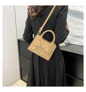 Rear view of a khaki bow-knot handbag with heart crystal and adjustable shoulder strap