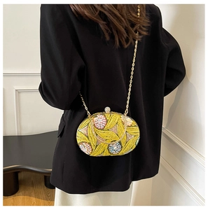 Vue détaillée d'une pochette jaune à fleurs pailletées portée sur une veste de costume noire