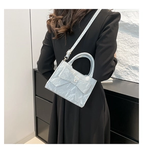 Detail showing the light blue pearlescent bow and heart rhinestone on a crossbody bag
