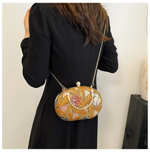 Détail d'une pochette de soirée à paillettes avec chaîne dorée sur une robe noire