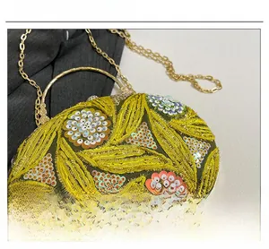 Détail montrant des paillettes jaunes et vertes avec broderie artisanale sur une pochette