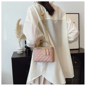 Detailed side view of pink quilted box bag with gold floral clasp and chain strap
