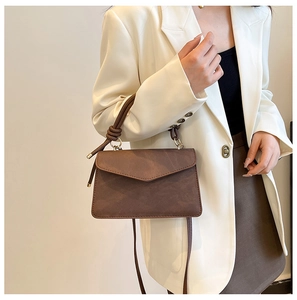 Brown vintage flap handbag featuring unique knotted handle detail and smooth matte finish