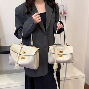 Minimalist beige leather tote bag with gold lock buckle and adjustable shoulder strap