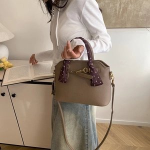 Brown grainy leather tote bag with a polka dot scarf handle and a long shoulder strap